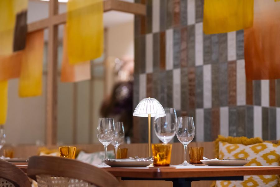 A laid table at The Gardens Mall beneath hanging fabric panels